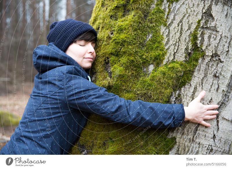 Woman with bobble hat hugs moss covered tree Tree Forest Brandenburg Moss Nature Exterior shot Colour photo Environment Landscape Day Plant Green Autumn