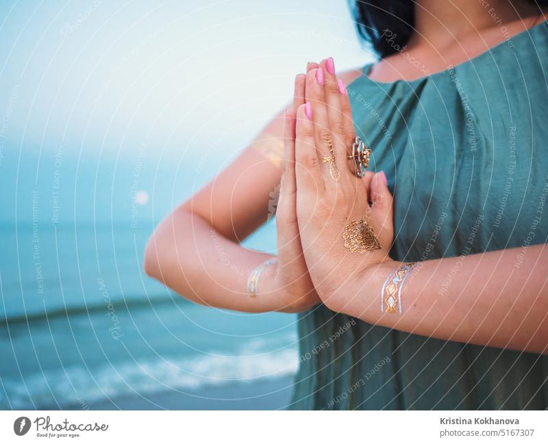 Woman practicing yoga. Namaste, meditation. Silver and golden flash tattoo fashion hand young beauty female girl beautiful model person white body bracelet lady