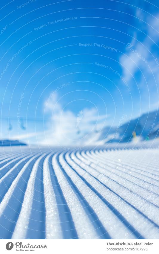 Fresh slope with chairlift in background against blue sky Snow Ski piste Cross-country ski trail chair lift Ski resort Blue sky Cold Pattern Winter