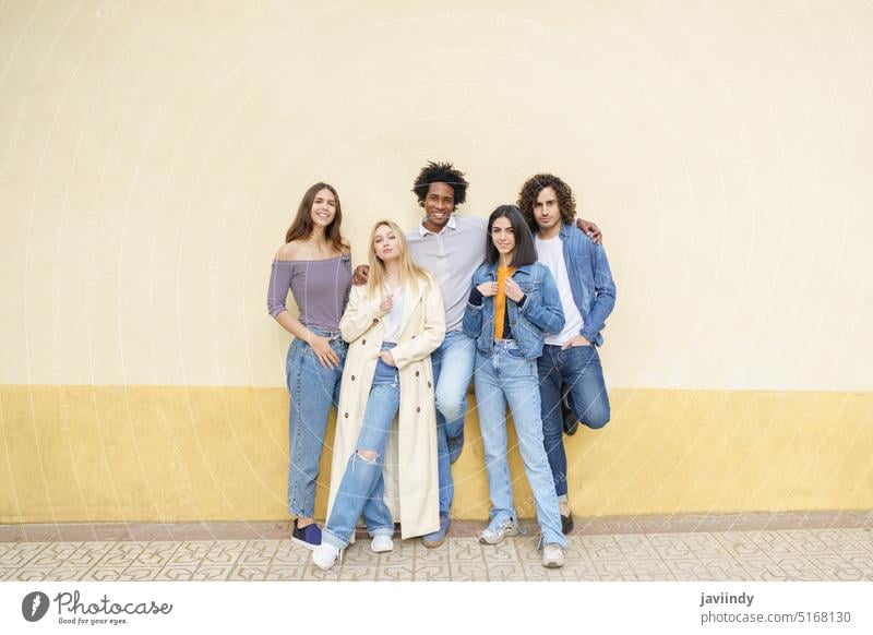 Multi-ethnic group of friends posing while having fun and laughing together people multi-ethnic diversity multiracial outdoors outside street urban men women