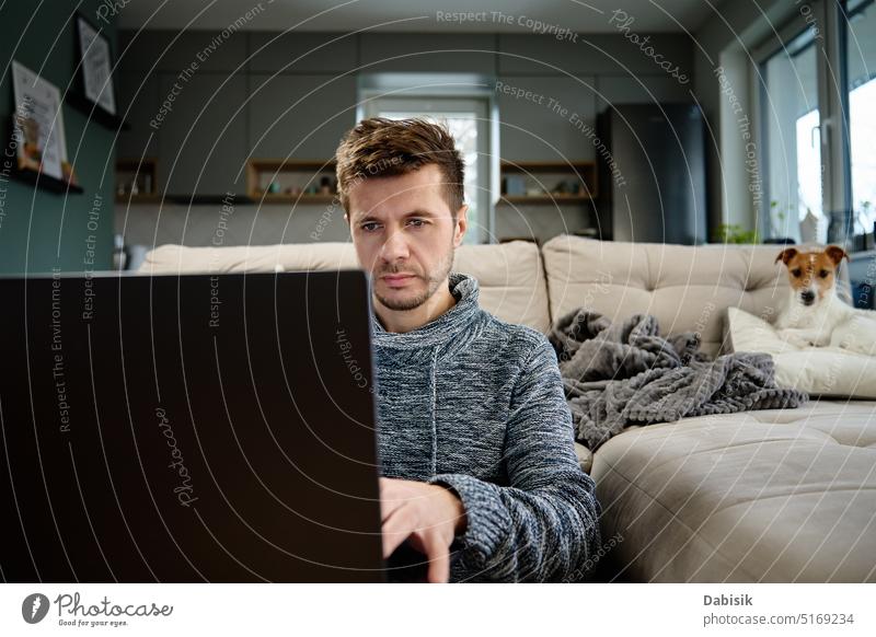 Man using laptop at living room work home man remote lifestyle online freelancer work from home dog pet busy business workplace interior portrait internet