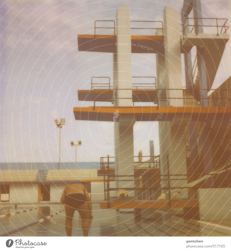 Humor man in swimming trunks bending down in front of swimming pool and diving tower in the open air pool Leisure and hobbies Sports Swimming & Bathing