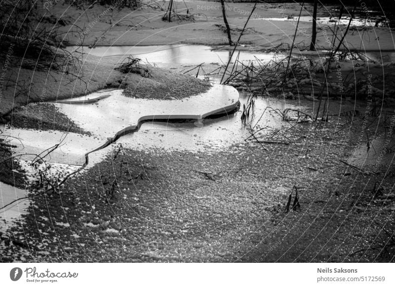 water settles down, ice breaking winter broken ice pond river sunlight winter evening snow cold frost freezing crack line shape coast shore river bank smooth