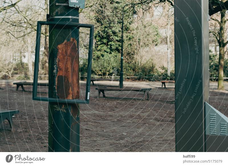 empty metal frame on a pole in the park Frame Bracket Warning sign Signage Metal Line Sharp-edged Bizarre Retro Broken Signs and labeling void Free space piers