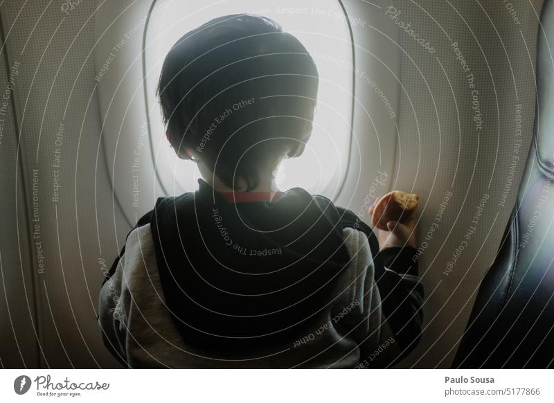 Rear view child looking through airplane window Child childhood Airplane Window Airplane window Sky Vacation & Travel Aviation View from the airplane Clouds