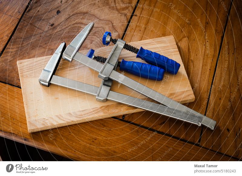 Wood clamps used to restore furniture France ancient antique attach background board clip close-up closeup concept construction craft detail equipment hardwood