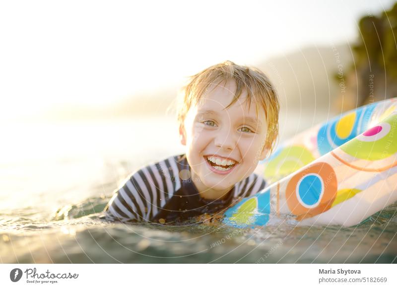 Little boy swimming with colorful floating ring in sea on sunny summer day. Cute child playing in clean water. Family and kids resort holiday during summer vacations.