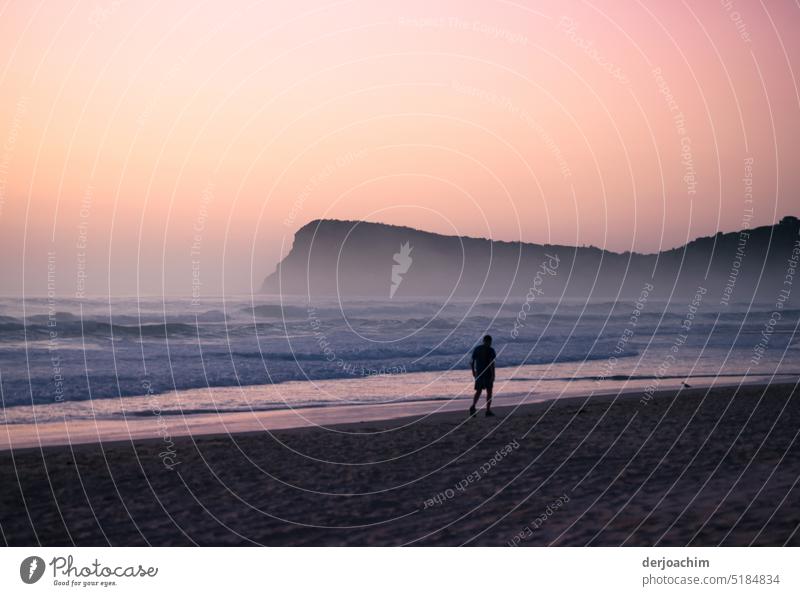 This lure of the morning light could not resist the hiker on the beach of Lennox Head. With in the picture , the headland jutting into the sea. Dawn