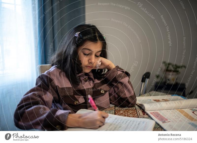 Little girl doing some homework at home, writing and learning people person education indoors lifestyles female pretty casual sit table cute girls serene book