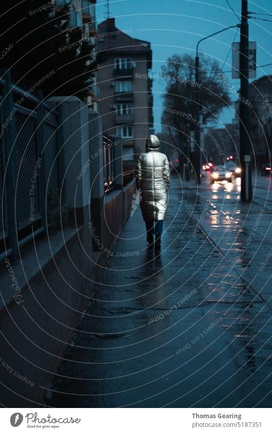 Lone woman walking in the rain female raindrops Dark Moody moody atmosphere moody weather moody portrait Reflection in the water Night Night shot darkness