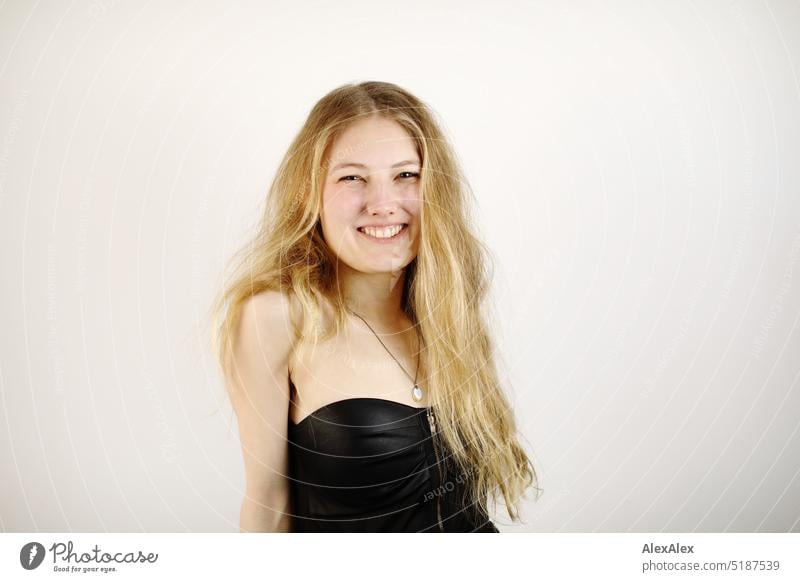 Close portrait of young blonde woman standing in front of white background Fresh Looking into the camera Expectation inside Self-confident feminine Charming