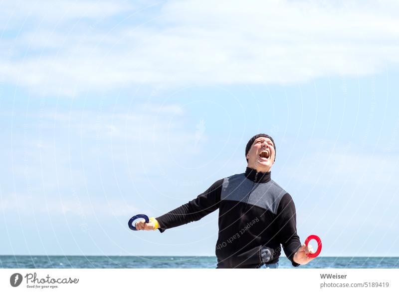 A man steers a kite on the beach and feels enthusiasm mixed with great excitement emotion fun Tension Joy Enthusiasm Laughter watch kites Steering Beach Ocean