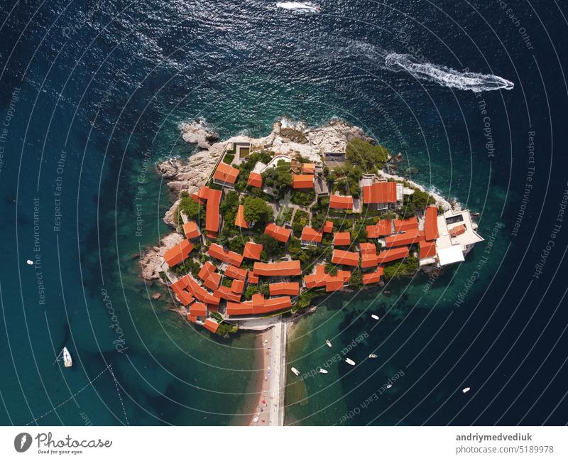 Aerophotography. Aerial view of Sveti Stefan island in a beautiful summer day, Montenegro from flying drone. Panoramic above view of Saint Stephen luxury resort. Tourism and leisure concept.