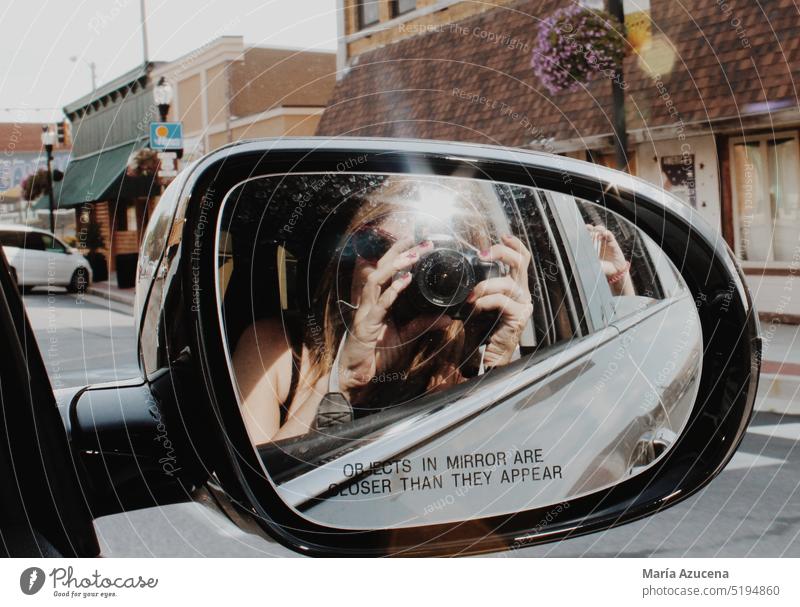 Woman reflected in the rearview mirror of a car, taking a photo on Route 66. Mirror Photography Mirror image camera Take a photo Looking into the camera Camera