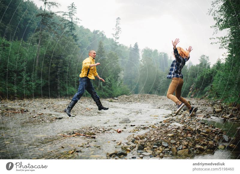 Playful happy handsome couple having while walking in woods. tourists in the mountains. Adventure in nature concept. active relationship love playful piggyback