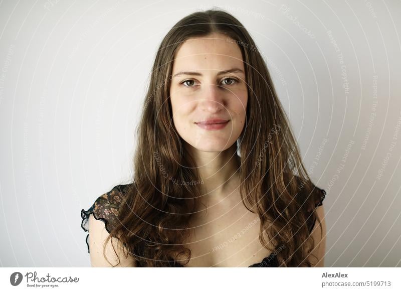 Portrait of a young brunette woman in a dark summer dress in front of a white wall Face Face of a woman Woman Young woman pretty daintily Brunette Bright Adults