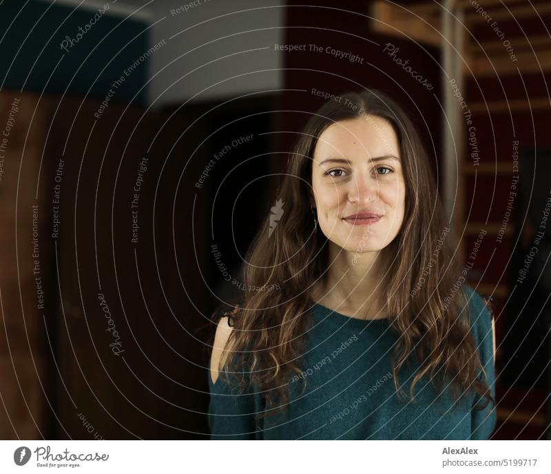 Portrait of young brunette woman with off shoulder sweater in room with wall bars Face Face of a woman Woman Young woman pretty daintily Brunette Bright Adults