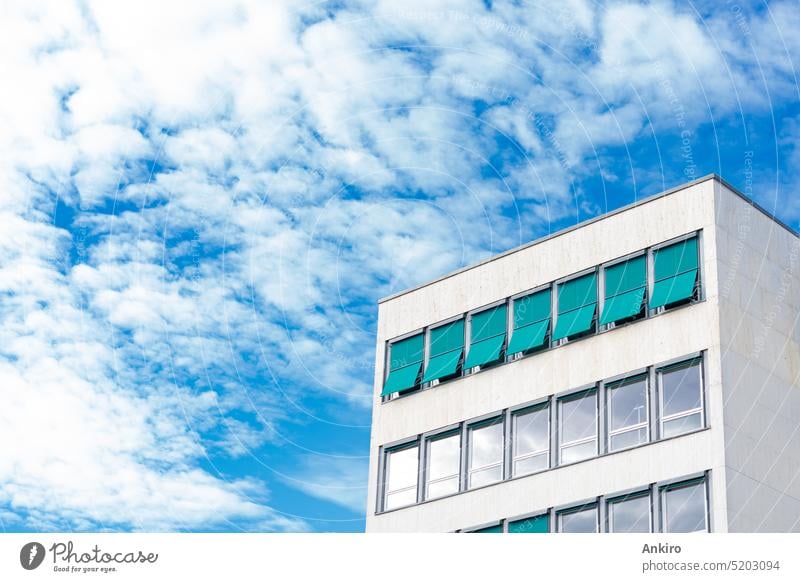 Modern office building with many windows and turquoise sunscreen architecture house city sky clouds copy space urban glass facade geometric design structure row