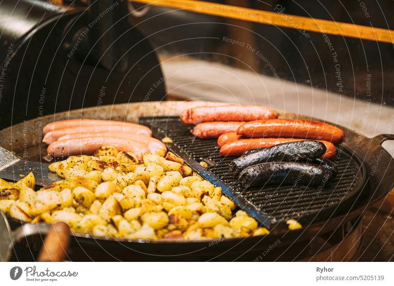 Frying Potatoes And Sausages - A Traditional Christmas Dish Of Street Food On Streets Of Europe In Winter During The Christmas Holidays junk food hot tallinn