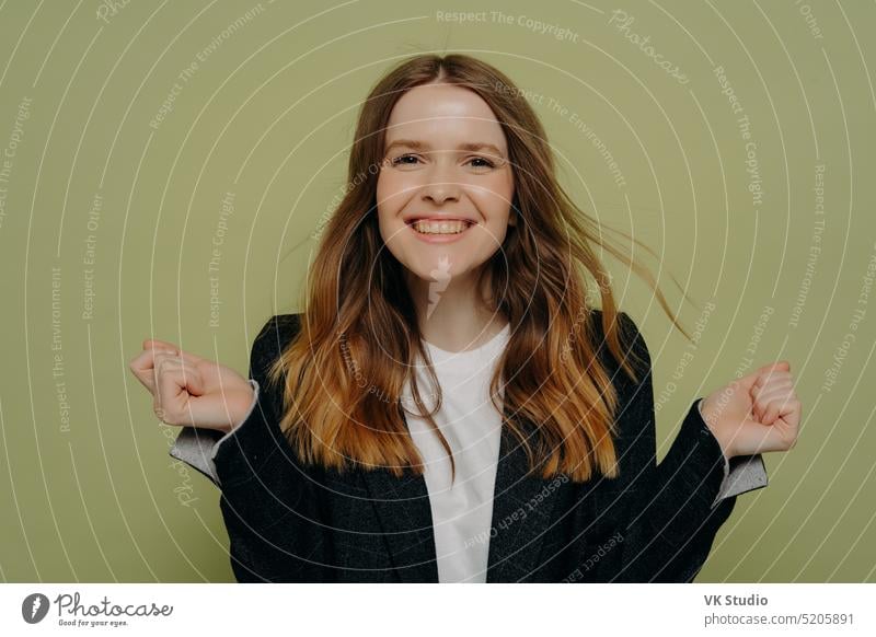 Happy beautiful girl in formal wear showing excitement woman young positive victory teenager success excited demonstrating fist clenched happy female casual