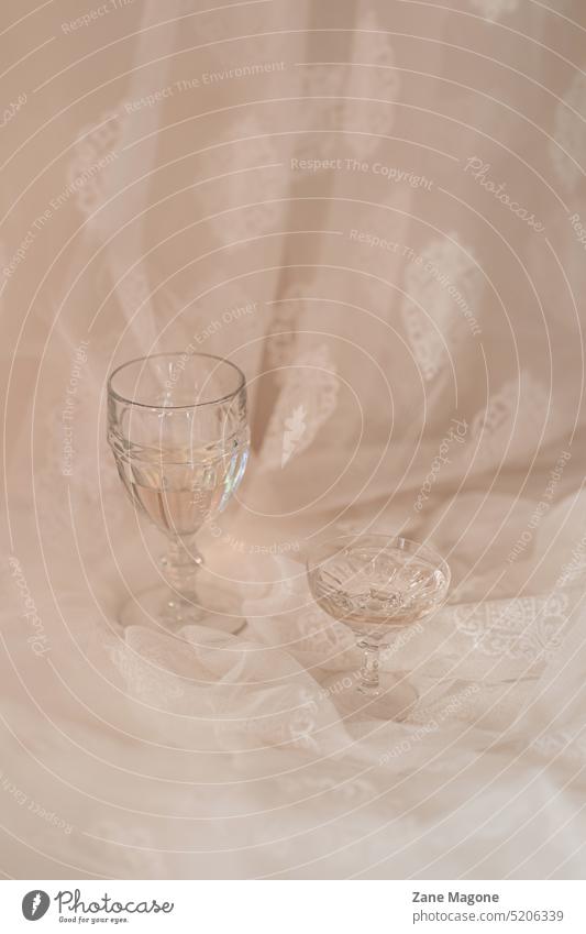 Elegant glasses with drinks on dreamy background parisien chic aesthetic celebration elegant twenties beige pink pastel cloth styled sparkling wine champagne