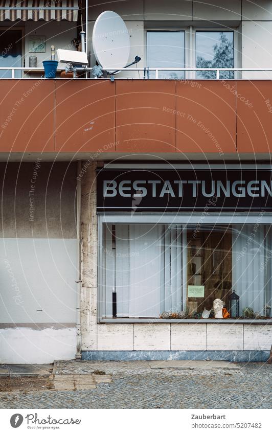 Funeral showcase of a mortician, mourning and loss, above balcony and satellite dish as geometric facade ensemble Funerals Shop window Grief Death case of death