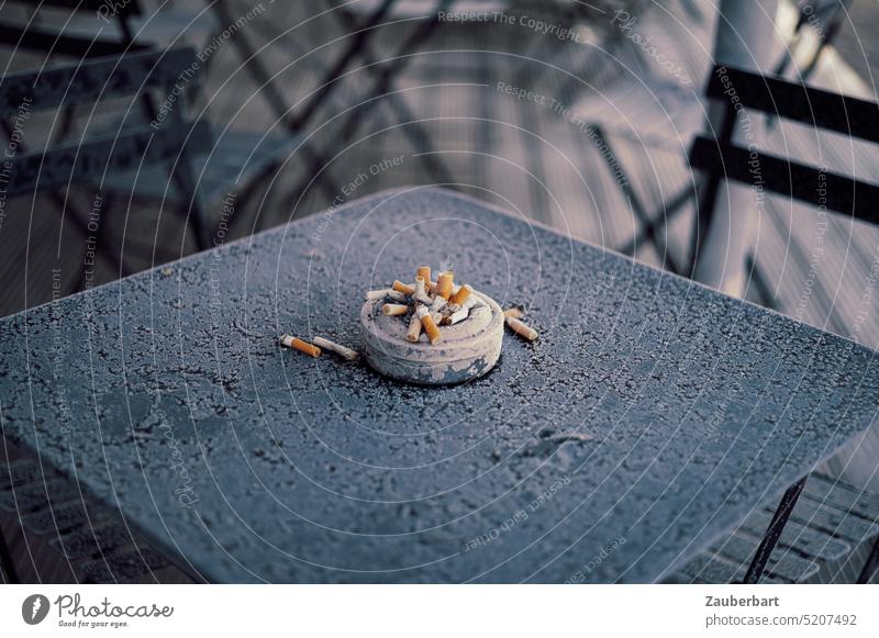 Full ashtray with cigarette butts on icy garden table Ashtray Cigarette Smoking dumb Cigarette Butt stop Table icily Garden table Cold out go out intent Good