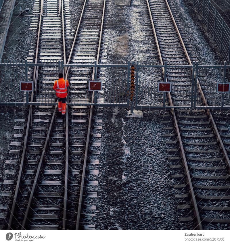 Closed railroad tracks, workers in red warning clothes, strike Track Railway track Lateness train failure lock Barred Fence passage Strike Working man