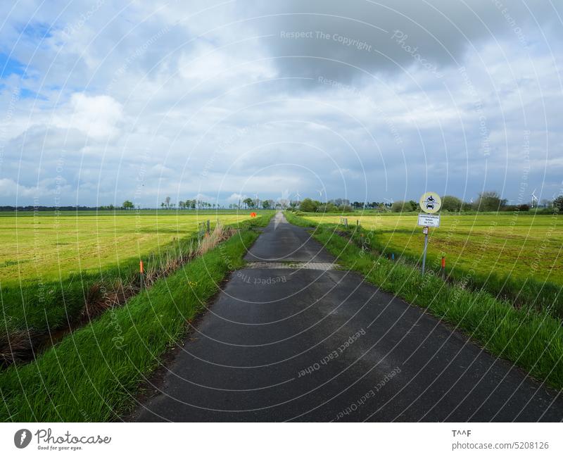 Wind turbines at gas storage Huntorf - farm road through the meadows with gas pipeline, wind turbines and rainy weather Huntebrück Meadow Rain