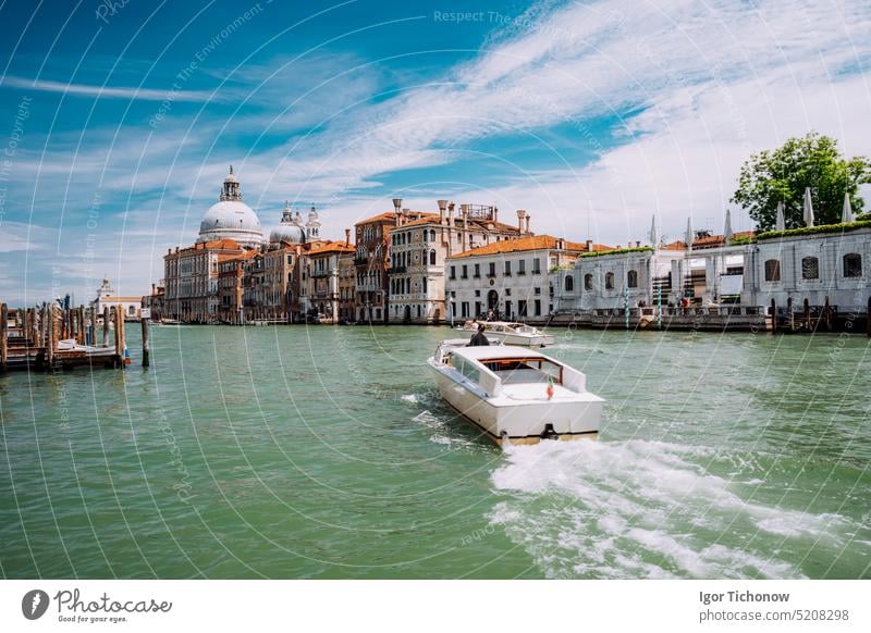 Grand Canal tourist boat with Basilica Santa Maria della Salute against blue sky and white clouds, Venice, Italy italy cathedral venezia turquoise sightseeing