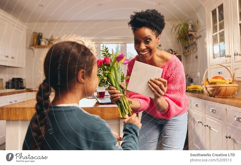 Boy giving mother bouquet and card on Mothering Sunday or Birthday mothers day birthday gift child boy son flower give family parent surprise celebration kind