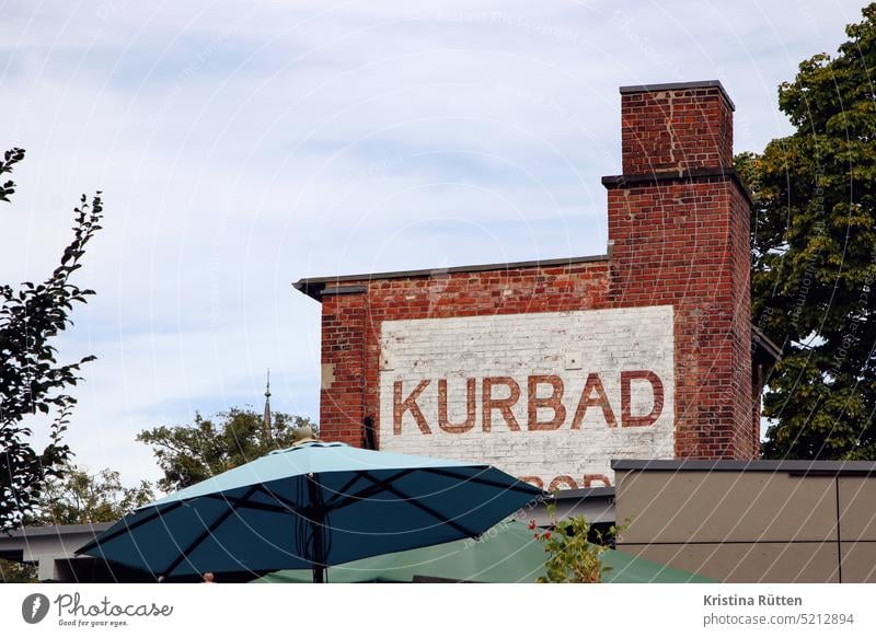 spa stands on the brick wall Cure Bathroom writing painted on Wall (building) Wall (barrier) Facade Building Chimney out Sunshade Terrace Café Cultural monument