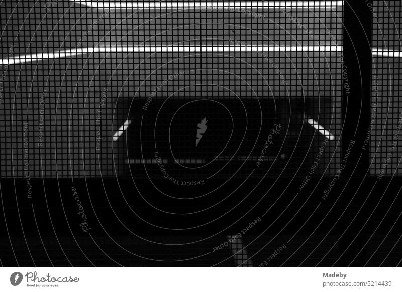 Closed grille at the entrance to the underground parking garage of a high-rise building in Neue Mainzer Straße in the city center of Frankfurt am Main in Hesse in neorealistic black and white