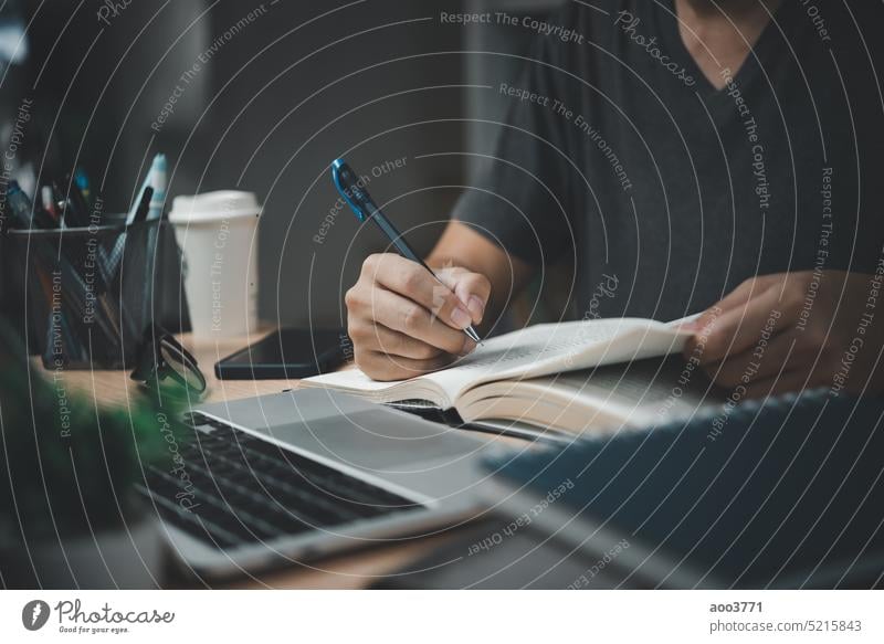 man hands with pen writing on notebook in the office.learning, education and work.writes goals, plans, make to do and wish list on desk. content script