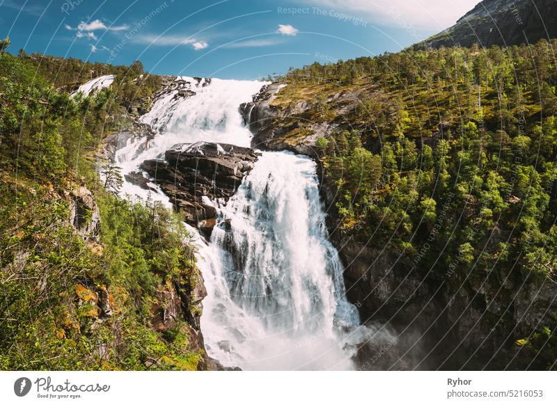 Kinsarvik, Hordaland, Norway. Waterfall Nyastolfossen In Hardangervidda Mountain Plateau. Nyastolsfossen in Spring Sunny Day. Height Of 115 m. Norwegian Landmark And Popular Destination