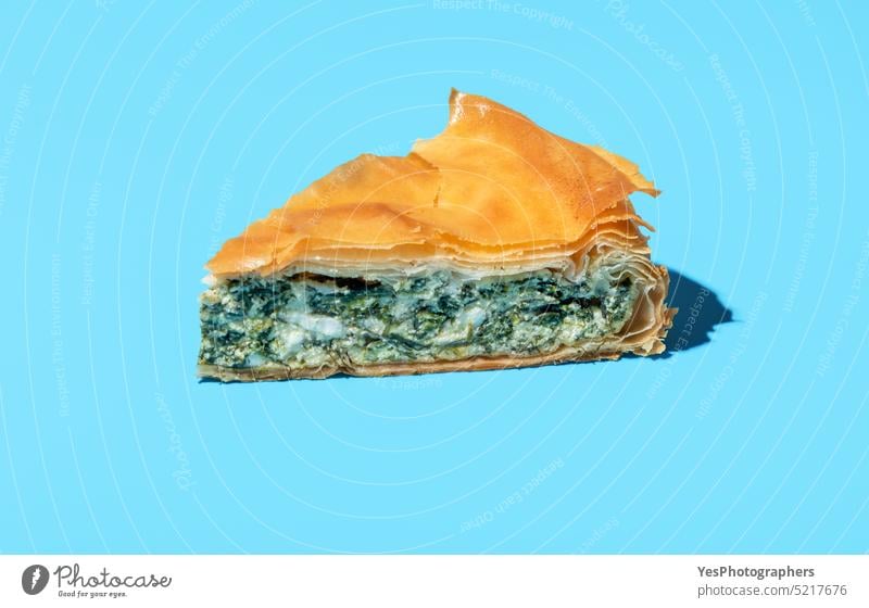 Phyllo cake slice minimalist on a blue background. Cheese and spinach pie. baked balkan banitsa bright bulgarian cheese color cuisine delicious dinner dough