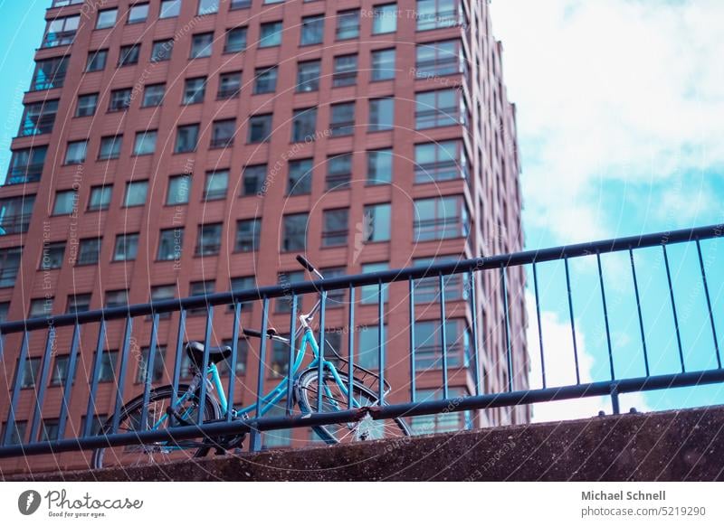 Bicycle on a bridge framed by a skyscraper Transport Means of transport Bridge Bridge railing Traffic infrastructure Road traffic Street Cycling Driving