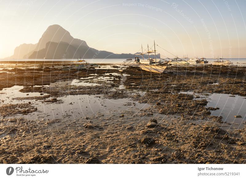 El Nido, Banca boat in low tide. Sunset behind beautiful Cadlao island. Palawan island, Philippines reflection philippines view palawan sunset cadlao el nido