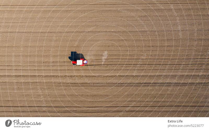 Aerial view on tractor as spread fertilizer over agricultural field Above Agriculture Arable Artificial Barley Care Cereal Chemical Country Crop Cultivated