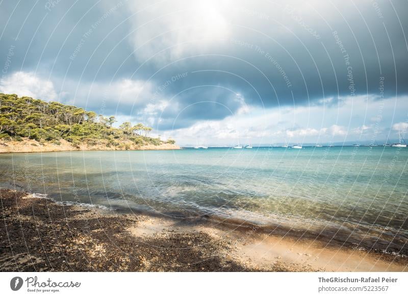 Beach against dramatic sky Ocean Porquerolles France Island Vacation & Travel Water Relaxation Sky coast Summer Exterior shot trees bathe vacation popular