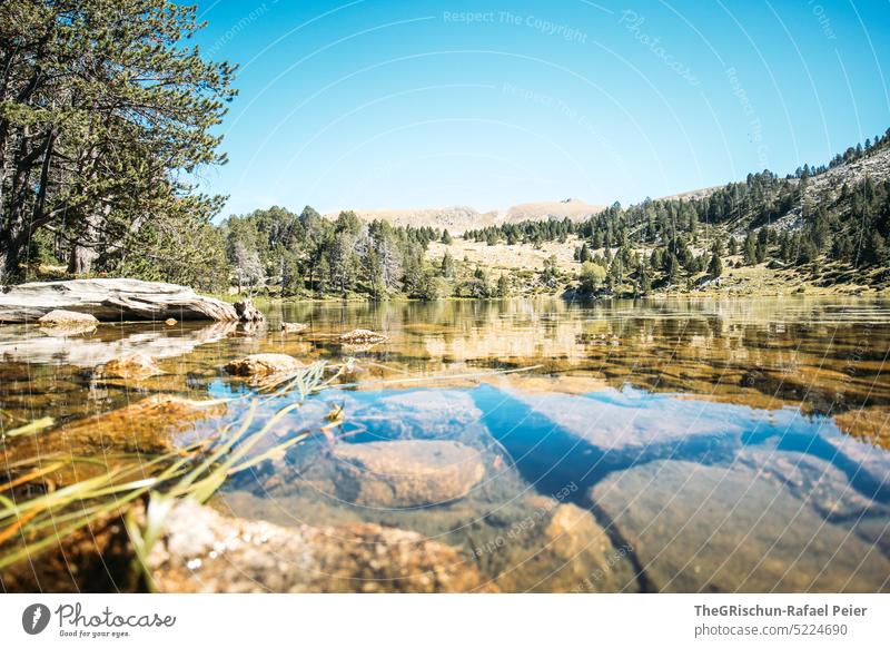 Stones in water by lake Alps Andorra Hiking Discover Mountain Hill Landscape Nature Colour photo Summer Deserted Tourism Beautiful weather Lake stones Water