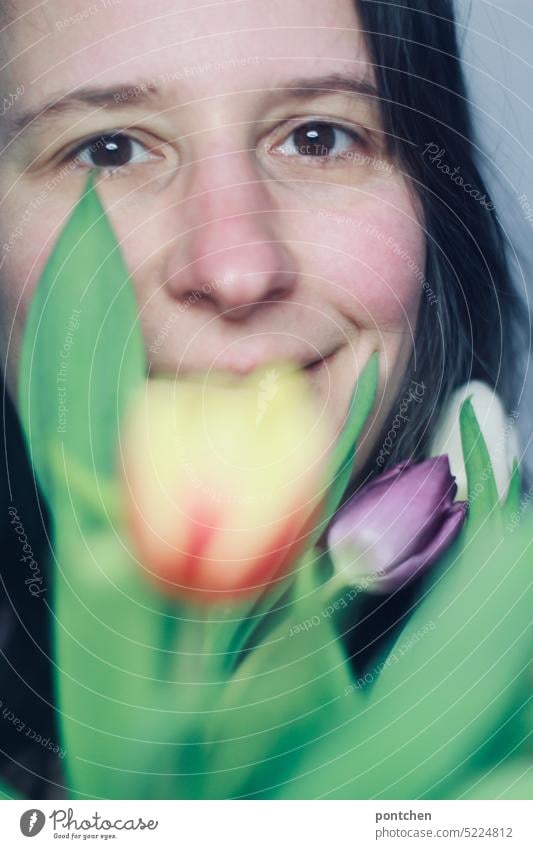 smiling woman in front of a bouquet of tulips partially covering her face Woman Smiling cheerful Spring Bouquet Gift Flower Blossom pretty Tulip Mother's Day