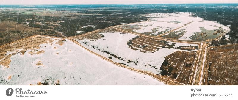 Aerial View Of Road Through Ponds In Winter Snowy Landscape. Frozen Ponds Of Fisheries In South Of Belarus. Top View Of Fish Farms From High Attitude. Drone View. Bird's Eye View