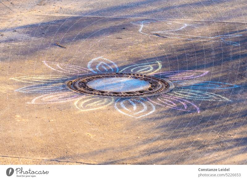 Flowering manhole cover in sunlight slop Chalk drawing blossom Sunlight colored Drawing Shadow play pretty Playing Street painting Infancy Creativity