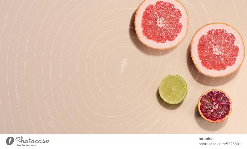 Sliced pieces of orange, lime and grapefruit on a beige background, top view lemon fresh citrus food no people sweet cut ingredient slice ripe juicy green juice