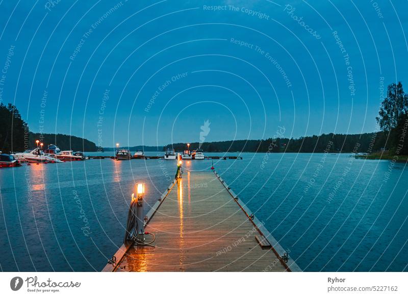 Sweden. Beautiful Wooden Pier Near Lake In Summer Evening Night. Lake Or River Landscape summer scene boat calm light park landscape pier Swedish water nature