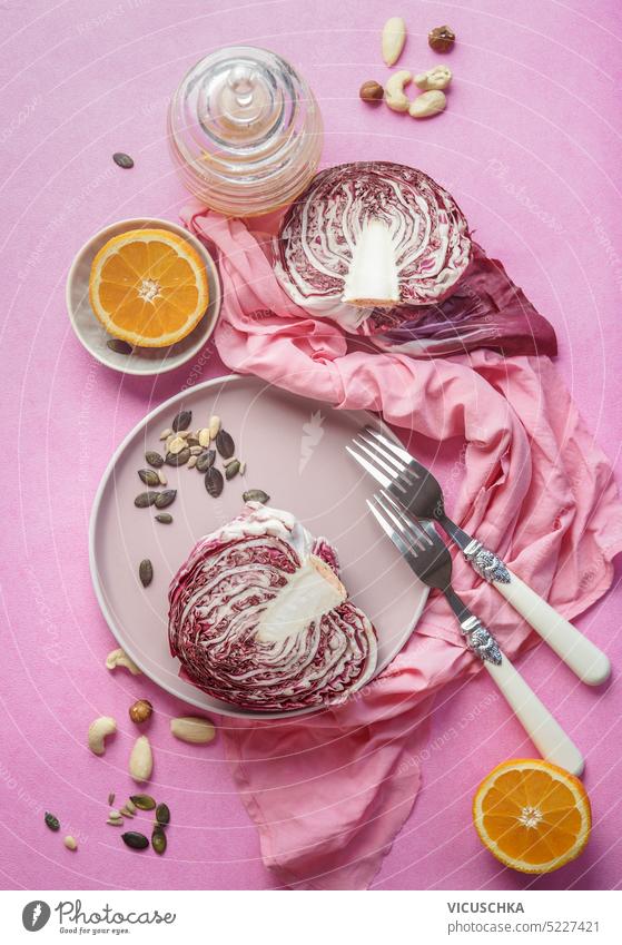 Halved radicchio on plate with forks and healthy salad ingredients, top view. Healthy food concept halved purple cabbage vegetable vegetarian cooking organic