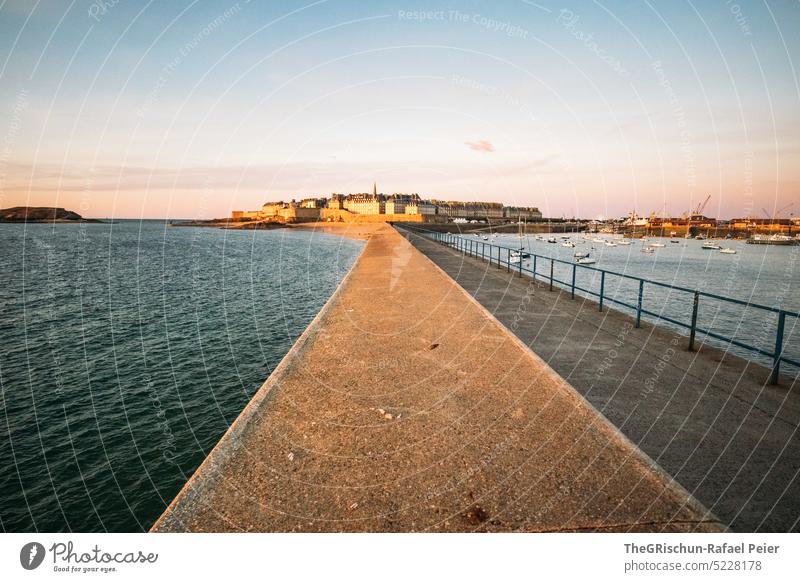 Jetty with city (Saint-Malo) in the background at evening mood Wall (barrier) Footbridge Ocean Bay Harbour Town Island France travel Tourism Brittany