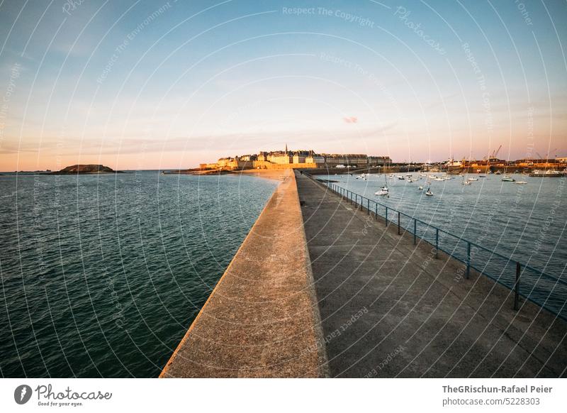 Jetty with city (Saint-Malo) in the background at evening mood Wall (barrier) Footbridge Ocean Bay Harbour Town Island France travel Tourism Brittany