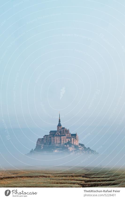 Dry riverbed in front of Mont Saint Michel in morning mist Meadow Blue sky Grass Landscape mont saint michel Mont St. Michel France Landmark Tourism